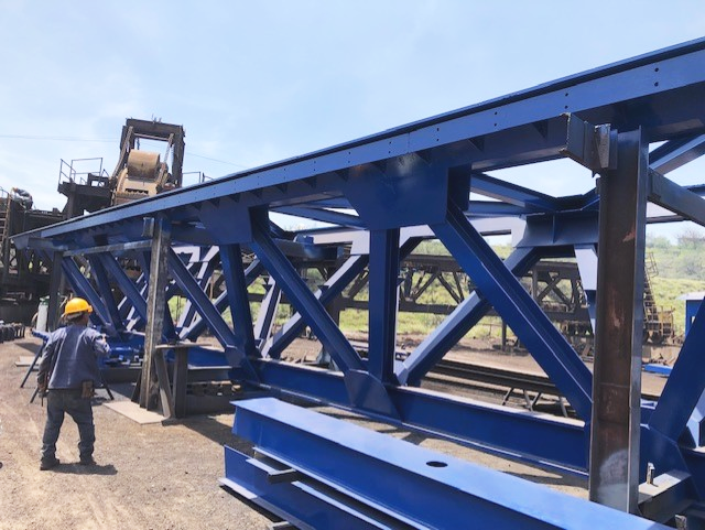 A close view of a newly constructed coke conveyor during coating application.