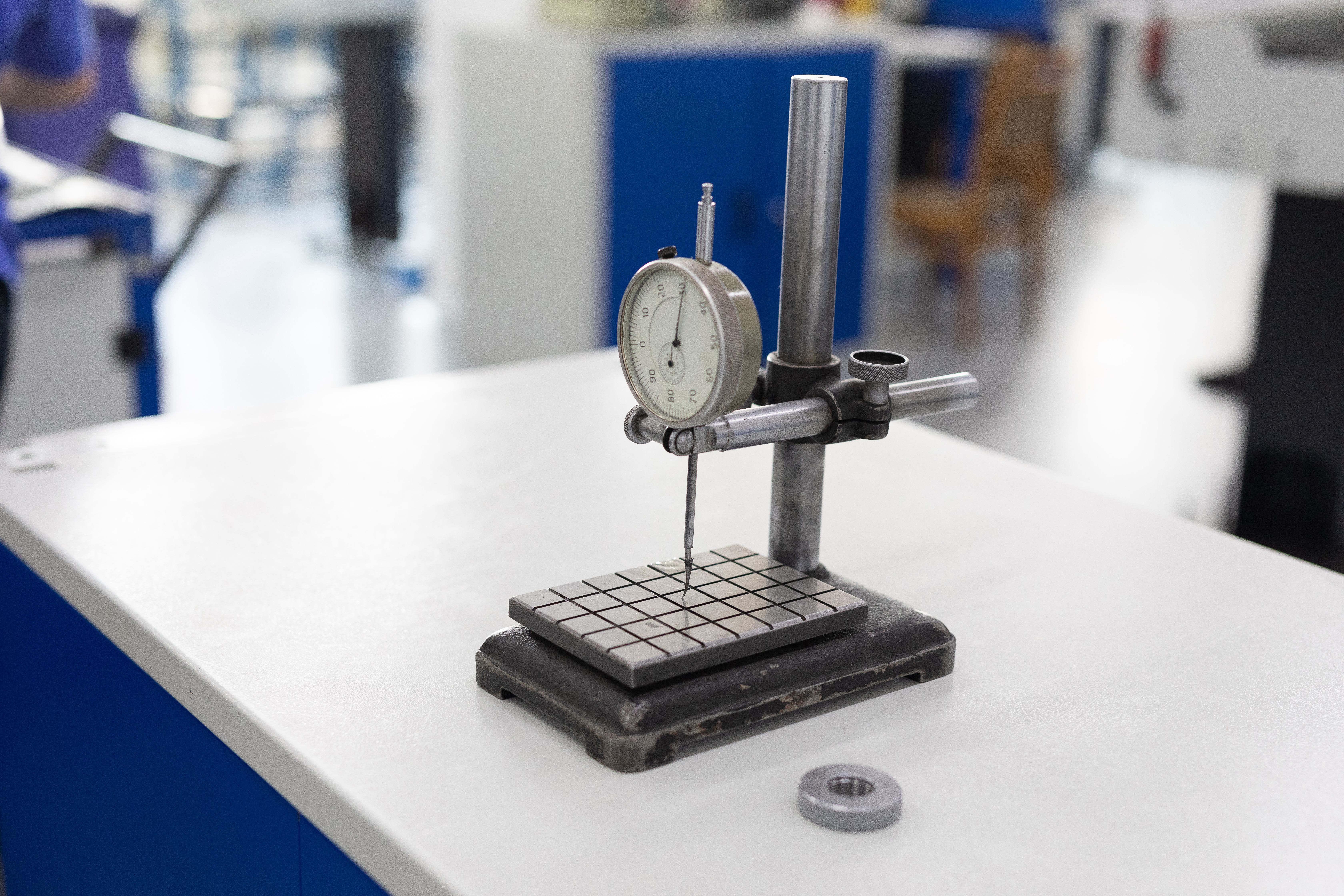 A durometer measures the hardness of a test specimen on a laboratory bench. 